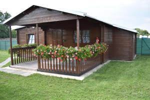 a small wooden house with flowers on a fence at Chata 1 in Nový Přerov