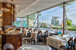 un restaurante con mesas y sillas y una gran ventana en Hotel Vistamare en Rímini