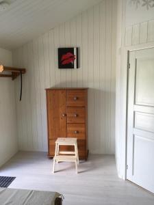 a bedroom with a wooden dresser and a stool at Långesjö lillstuga in Fjällbacka