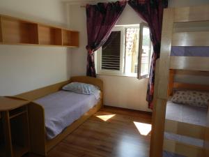 a small bedroom with a bed and a window at Apartmani Maruncic in Omiš