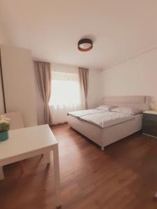 Schlafzimmer mit einem Bett, einem Tisch und einem Fenster in der Unterkunft Ferienwohnung Martinschitz in Sankt Kanzian am Klopeiner See