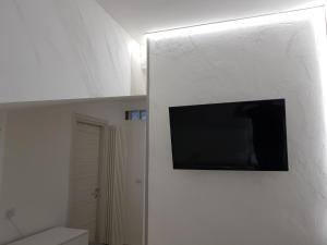 telewizor z płaskim ekranem wiszący na ścianie w łazience w obiekcie Alby suite w mieście Termoli
