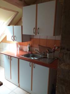 a kitchen with white cabinets and a sink at Świerkowe Rancho in Brzostek