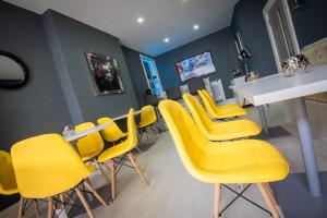 a waiting room with yellow chairs and a table at The Gables Hotel in Blackpool
