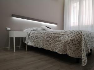 a bedroom with a bed with a table and a bedspread at Albergo Felice in Sottomarina
