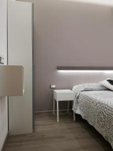 a white bedroom with a bed and a table at Albergo Felice in Sottomarina