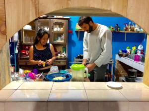 Ein Mann und eine Frau bereiten Essen in einer Küche vor. in der Unterkunft Cabañas Junkolal Tziscao in Santiago