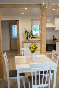 a kitchen with a white dining room table with white chairs at LiisuPesa Apartment with Sauna and Garden in Pärnu