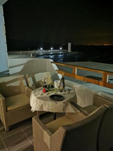 een tafel en stoelen op een balkon in de nacht bij Five star appartman Senj in Senj