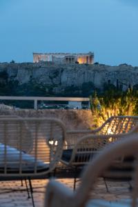 un grupo de bancos sentados en la cima de una colina en ATHENS STORIES, en Atenas