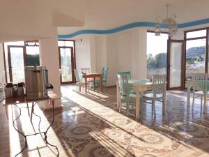 a dining room with a table and chairs and windows at kekil butik otel in Gokceada Town