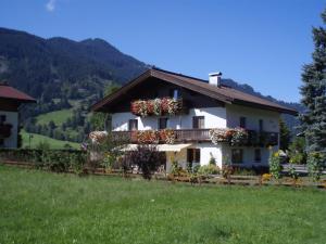 una casa con cajas de flores a un lado. en Ferienwohnungen - Haus Zierl, en Reith bei Kitzbühel