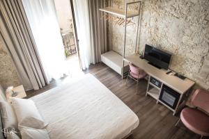 a bedroom with a bed and a desk with a television at Arcipelago 37 in Cagliari