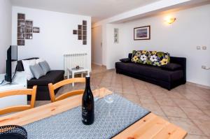 ein Wohnzimmer mit einer Flasche Wein auf dem Tisch in der Unterkunft Apartments Vanda in Rovinj