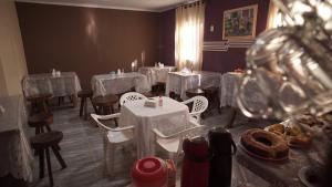 a dining room with white tables and chairs and candles at Pousada Centaurus in Alto Paraíso de Goiás