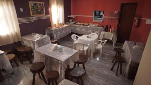 a restaurant with white tables and chairs and a counter at Pousada Centaurus in Alto Paraíso de Goiás