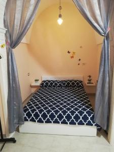 een slaapkamer met een bed met blauwe gordijnen bij Casa del Bicio in Ceglie Messapica