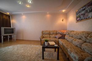sala de estar con sofá y TV en PaulMarie Apartments on 40 Stroiteley Street, en Soligorsk
