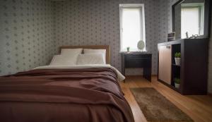 a bedroom with a bed and a table and two windows at PaulMarie Apartments on Zaslonova 74 in Soligorsk