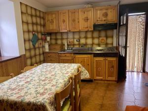 una cocina con armarios de madera y una mesa. en Il vecchio mulino - Alloggio ad uso turistico - VDA - INTROD - n 0006 en Introd