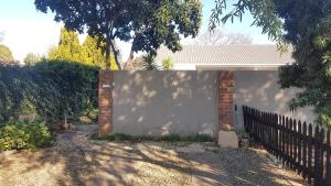 a fence in front of a white wall at De Dane Guestroom in Bloemfontein