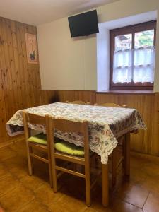 mesa y sillas con mesa y ventana en Il vecchio mulino - Alloggio ad uso turistico - VDA - INTROD - n 0006 en Introd