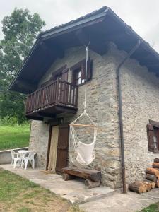 a stone house with a hammock and a balcony at Il vecchio mulino in Introd
