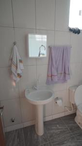 a white bathroom with a sink and a toilet at Pousada Centaurus in Alto Paraíso de Goiás