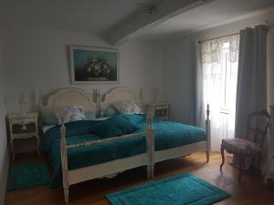 Un dormitorio con una cama con sábanas verdes y una ventana en Domaine de Mestrugue, en Montréal