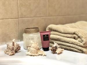 a candle and a jar on a bathroom counter with trees at Stylish Tel Aviv in Tel Aviv +121 photos