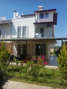 a large white house with a patio and flowers at Triblex Villa I Private Beach I Walking Distance to the Sea 300 meters in Side