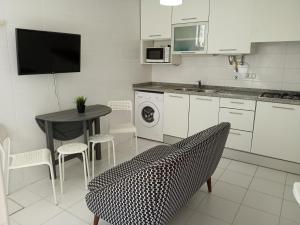 a kitchen with a table and a table and chairs at Casa Sao Marcos in Figueira da Foz