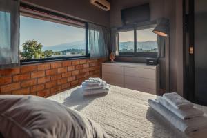 um quarto com toalhas numa cama com janelas em Casa Aurelio Wellness Suite & Spa Inclusive em Taormina