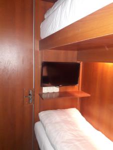 Onkel Inn Airport Sleepbox في لاباز: غرفة نوم بسريرين بطابقين وتلفزيون بشاشة مسطحة