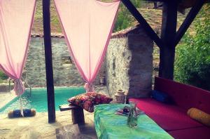 a room with a bed and a table next to a pool at Rancho i Vancho na Kata in Omorani