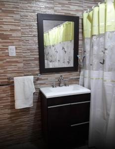 een badkamer met een wastafel en een douchegordijn bij LA CABAÑA in Termas de Río Hondo