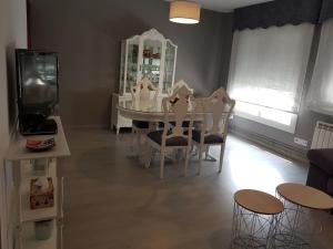 a dining room with a white table and chairs at Apartamento Las Hermanas in Pontevedra
