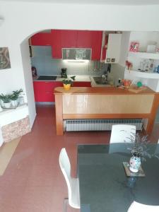 cocina con armarios rojos y mesa de cristal en Apartments Bosket, en Kastav