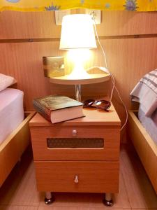 Marina D´or Asequible apartamento في أوروبيسا ديل مار: طاولة عليها مصباح وكتاب عليها