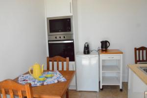 una pequeña cocina con mesa y microondas en Casa da Praia, en Carvoeiro