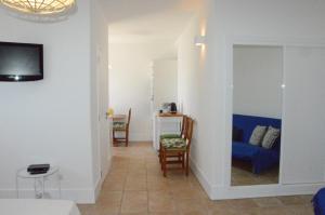 sala de estar con sofá azul y TV en Casa da Praia, en Carvoeiro