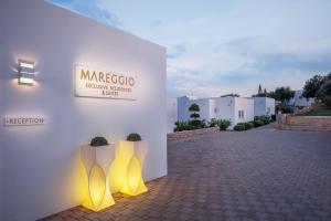 een gebouw met gele lichten aan de zijkant bij Mareggio Exclusive Residences & Suites in Gythio