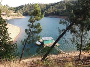 une petite maison au milieu d'un lac dans l'établissement Casa RioTempo + Jangada, à Tomar