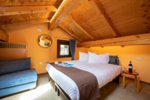 sypialnia z dużym łóżkiem i niebieską kanapą w obiekcie Chalet Rin Star w Livigno
