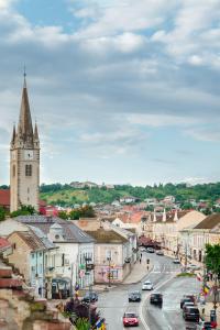 a city with a clock tower and a street with cars at Belle View Apart Hotel in Turda