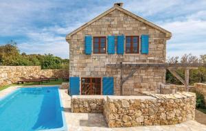 una casa de piedra con una piscina frente a ella en Mala Villa- private heated pool, en Novalja