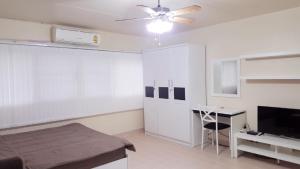 1 dormitorio con cama, escritorio y ventilador de techo en Condo C2 IMPACT, en Nonthaburi