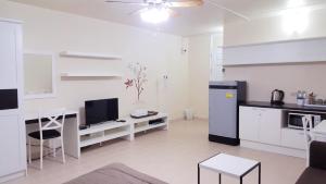 a white kitchen with a desk and a refrigerator at Condo C2 IMPACT in Nonthaburi