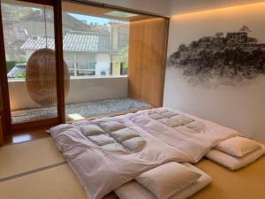 Un pat sau paturi într-o cameră la UTSUROI Tsuchiya Annex