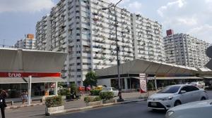 un aparcamiento con coches estacionados frente a un gran edificio en Condo C2 IMPACT en Nonthaburi